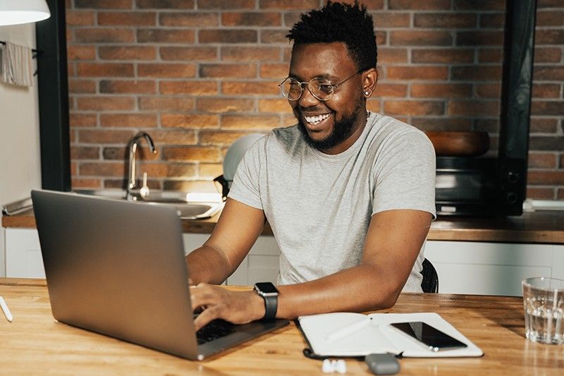 Man working on the laptop with smiling face