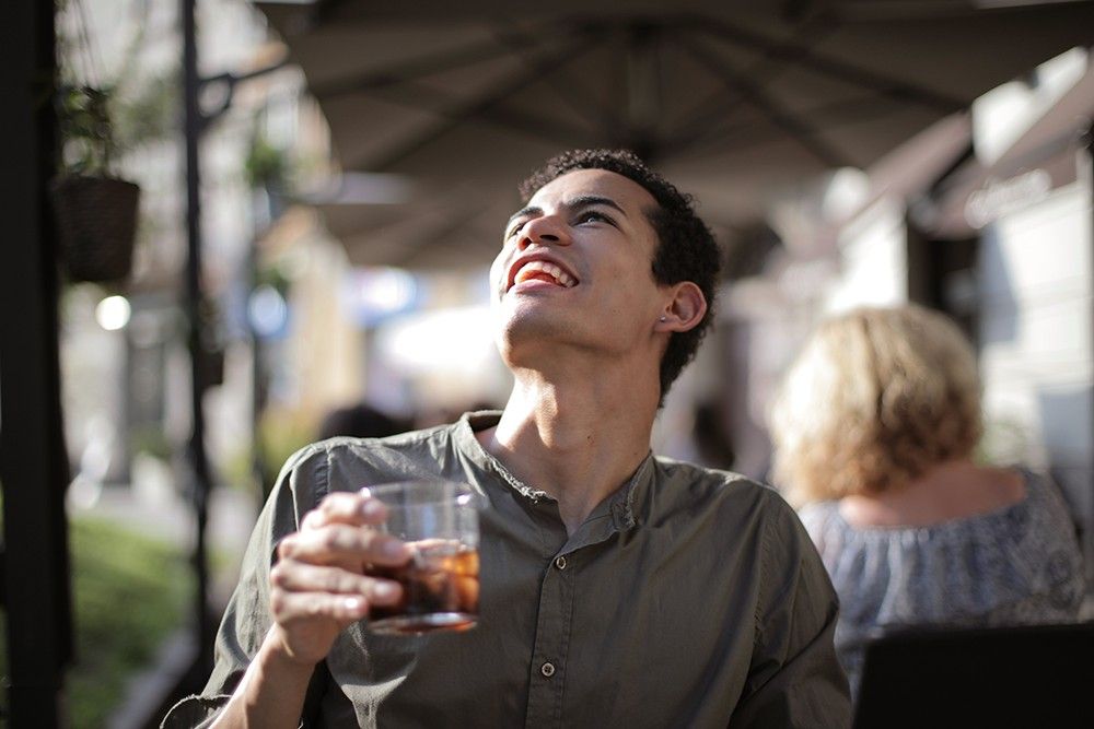 Person enjoying a drink outdoors
